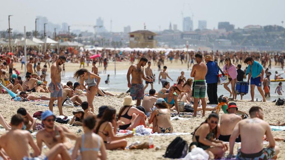 people enjoy the beach in tel aviv, 23 april