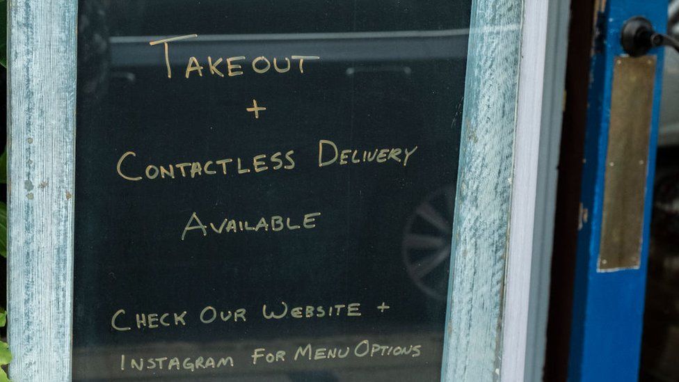A sign outside a restaurant in New Jersey offering takeaway and contactless delivery services during the coronavirus lockdown
