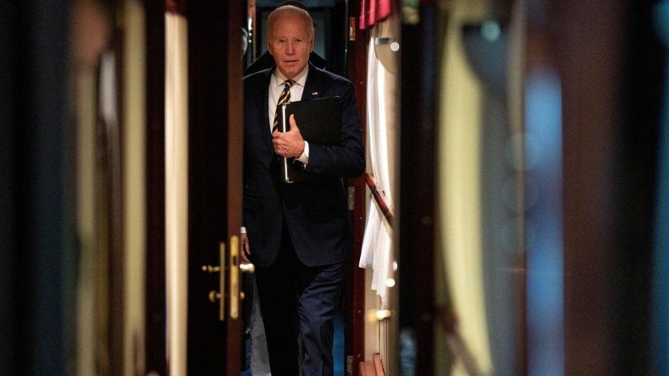 President Joe Biden walks down a corridor to his cabin on a train after a surprise visit with Ukrainian President Volodymyr Zelenskiy