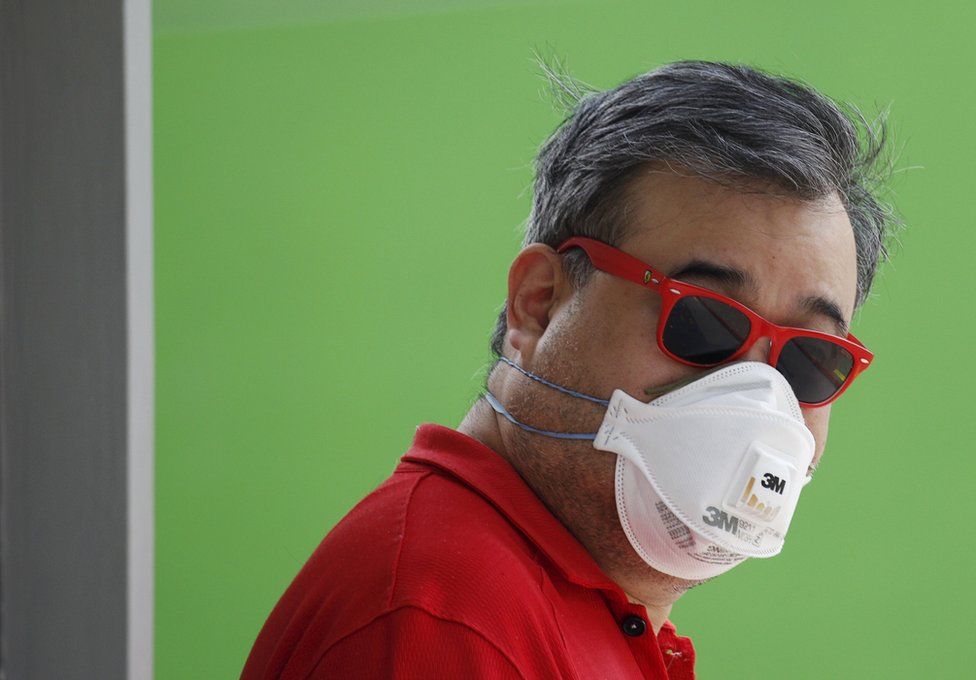 A man wearing a mask for protection against the haze as he waits at a polling station during the general election in Singapore 11 September 2015.