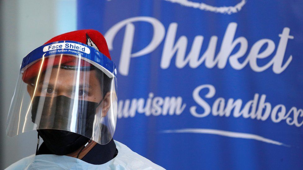 A member of airport security is seen during the arrival of foreign tourists at the airport as Phuket reopens to overseas tourists, allowing foreigners fully vaccinated against the coronavirus disease (COVID-19) to visit the resort island without quarantine, in Phuket, Thailand July 1, 2021.