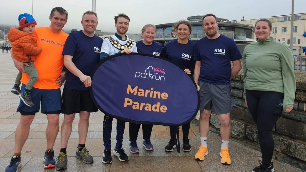 Mr Cronelly standing with members of the RNLI at the Marine Parade parkrun