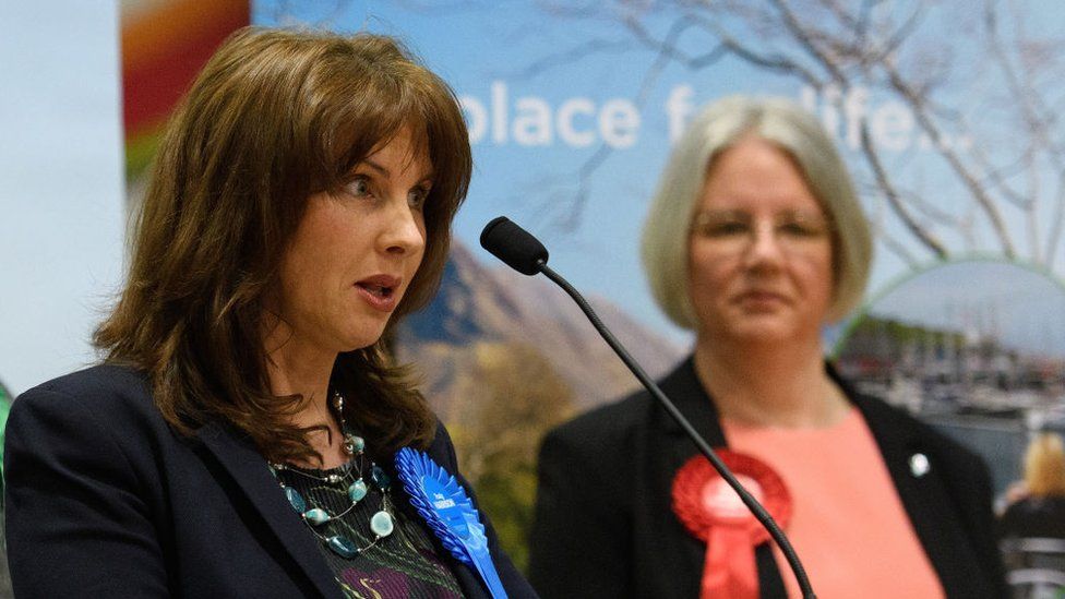Labour Party candidate Gillian Troughton (R) looks on as Conservative Party candidate Trudy Harrison speaks after winning the Copeland by-election