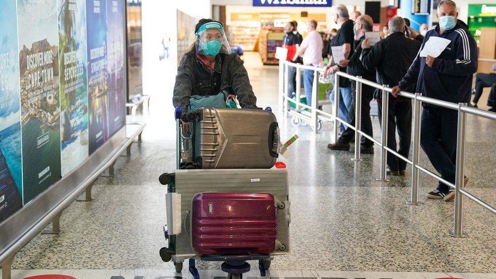 A person pushes a trolley full of luggage at Birmingham Aiport