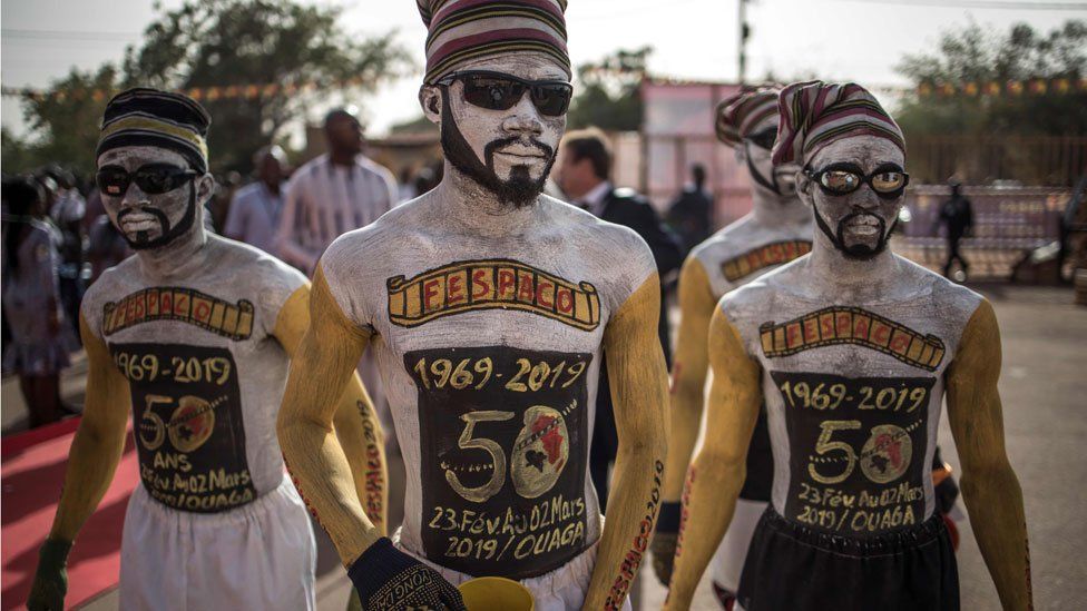 Performers arrive to the entrance of the venue where the opening ceremony of the FESPACO Panafrican Film and Television Festival of Ouagadougou is about to start, on February 23, 2019.