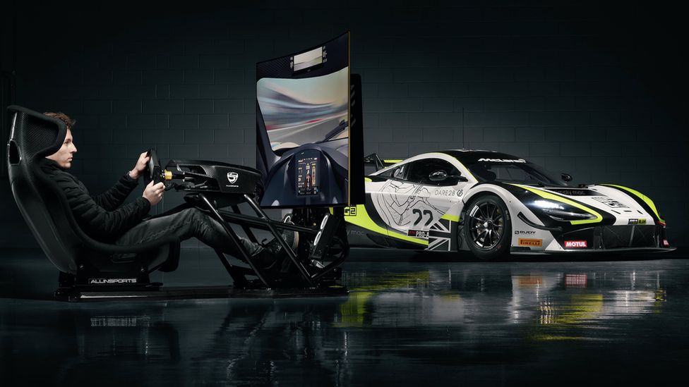 James alongside a racing simulator and real life GT car