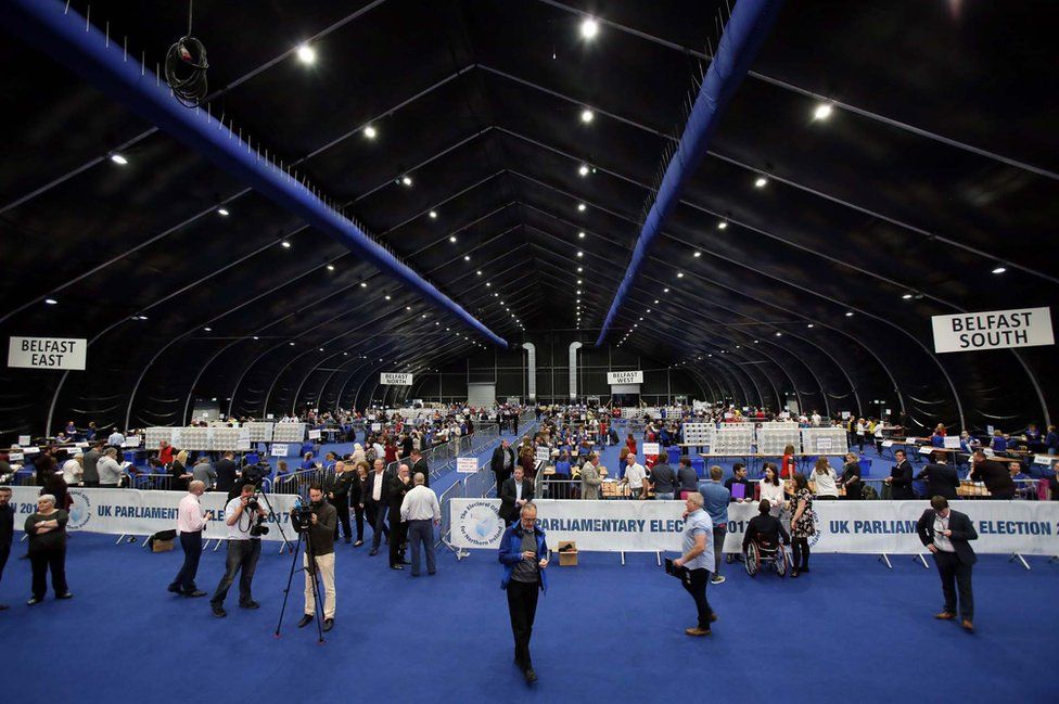 A picture shows a general view as counting staff sort through ballots at a counting centre in Titanic Exhibition in Belfast, Northern Ireland, on 8 June 2017