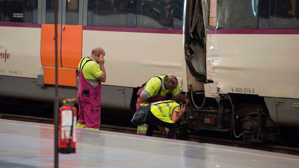 Railway technicians check a train carriage at Francia station in central Barcelona on 28 July 2017 after a regional train hit the buffers inside the station