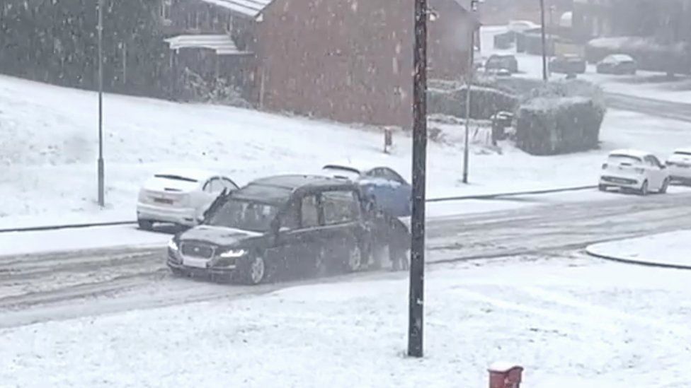 Hearse being pushed through snow