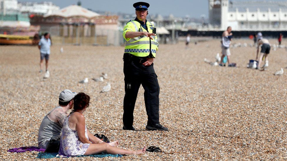Policeman talking to people on the beach