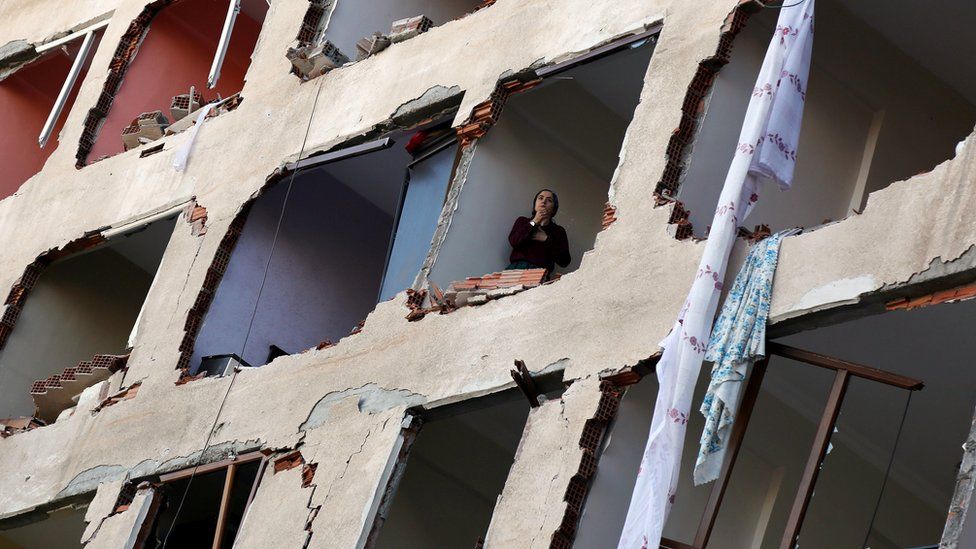 A woman looks out of a ruined building in Diyarbakir, 4 November