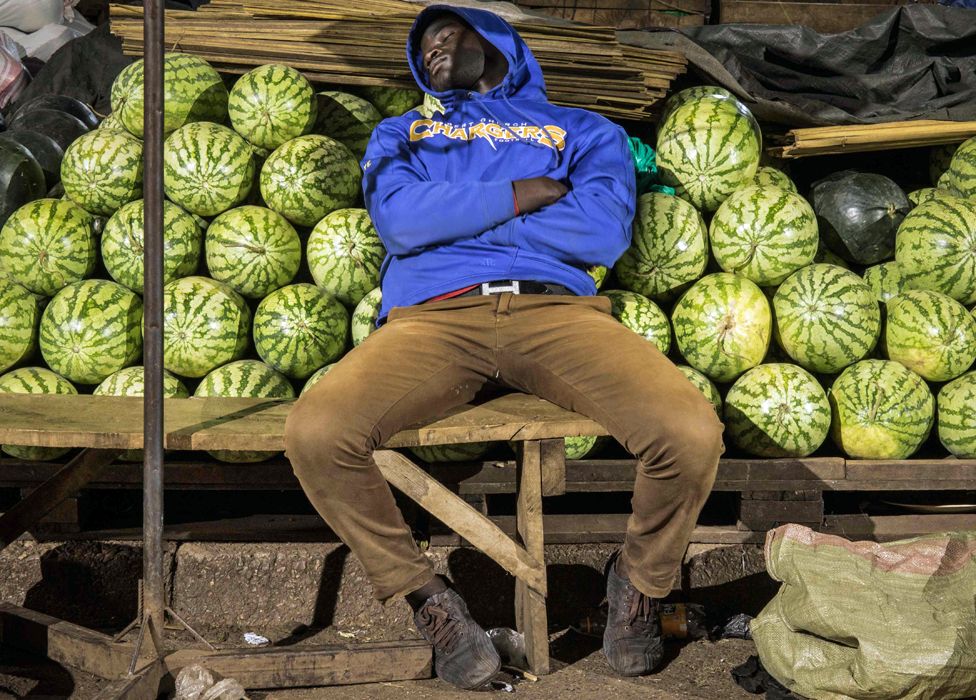 A trader sleeps by his melon stall in Kampala, Uganda - Wednesday 8 April 2020