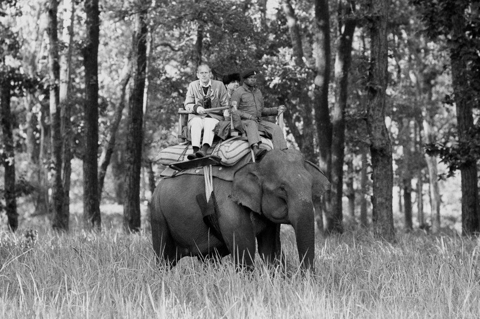 Duke of Edinburgh sitting atop an elephant while visiting the Kanha Game Reserve, 1983