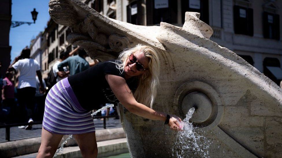 Image shows woman at Rome water fountain