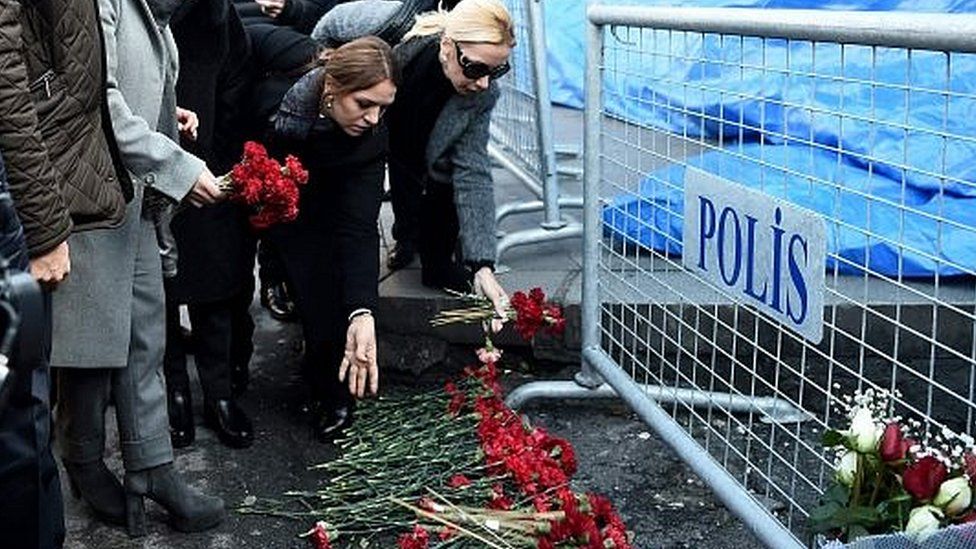 Flowers are placed next to Turkish police officers as they stand guard near the Reina nightclub, which was attacked by a gunman, in Istanbul, Turkey, on 1 January 2017
