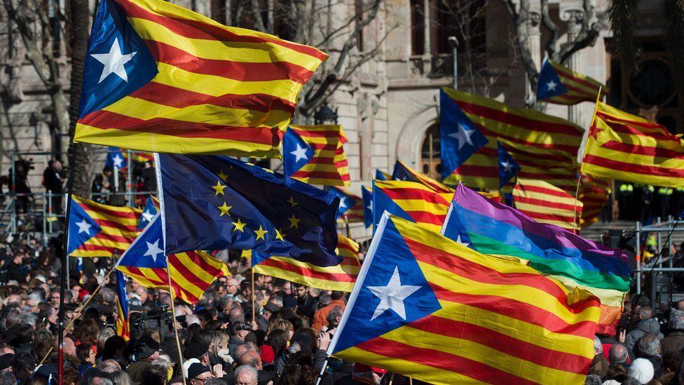 Catalan pro-independence flags, and a European Union flag, wave outside the Barcelona court house in February