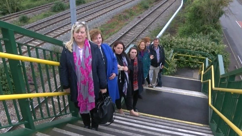 Campaigners on the footbridge over the railway