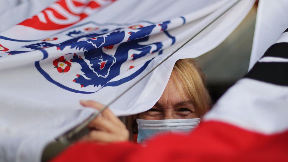 женщина с маской и флагом Англии