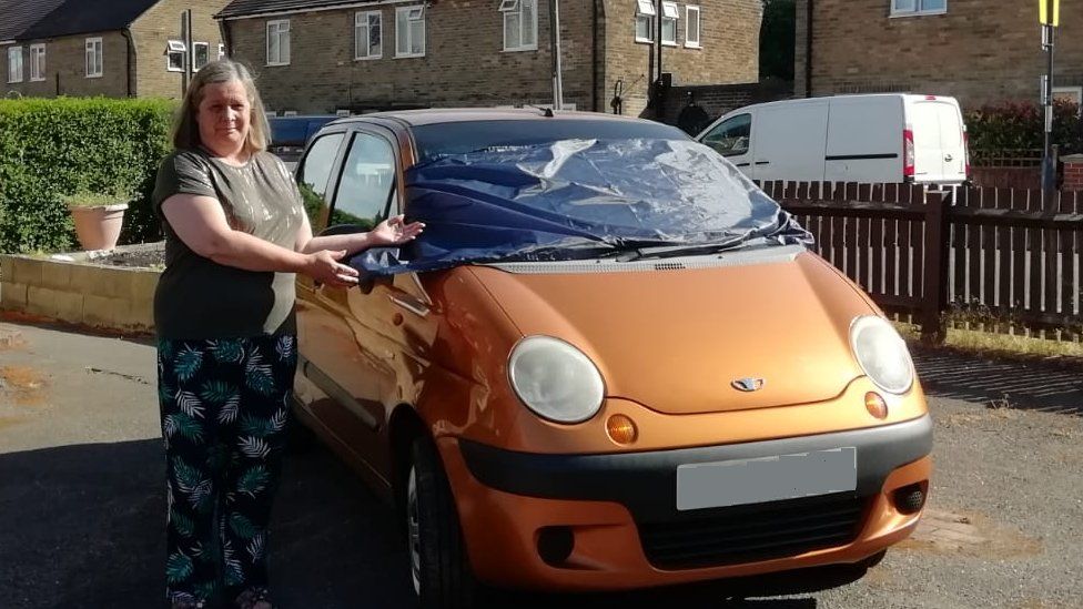 Julie Bannister with her car which has been damaged by crows in Littleover, Derby