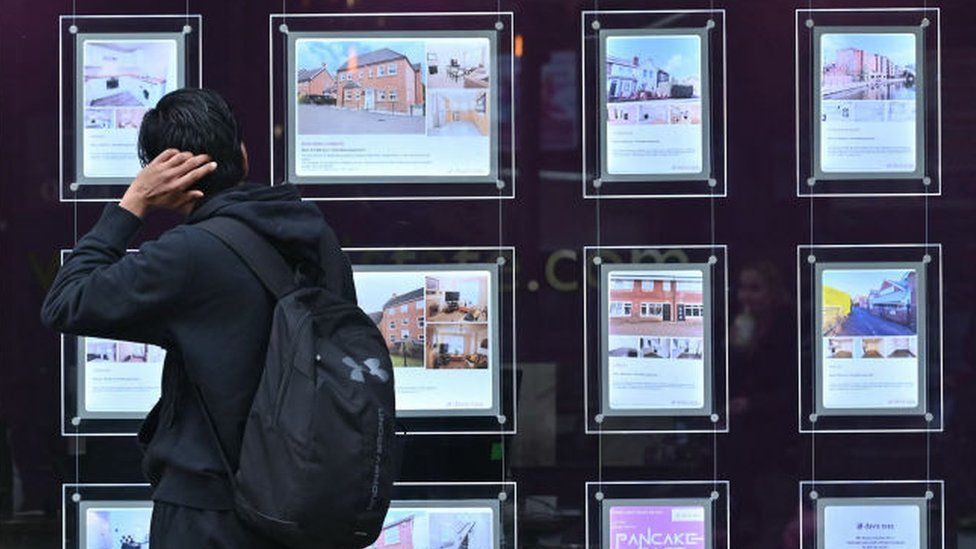 Person looks at estate agent's window