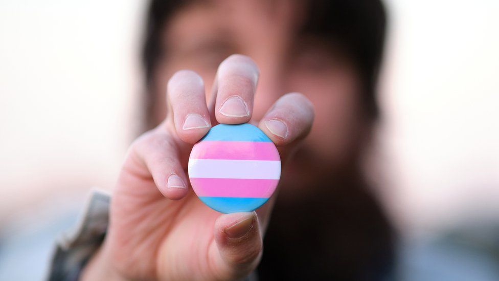 A pin badge with transgender colours flag