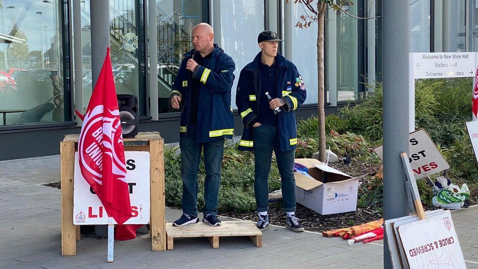 FBU member standing on a pallet addressing a protest