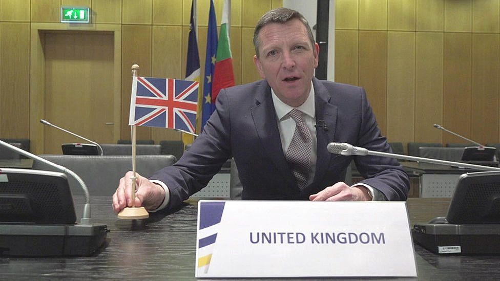 Mark Easton with UK flag in Europol boardroom
