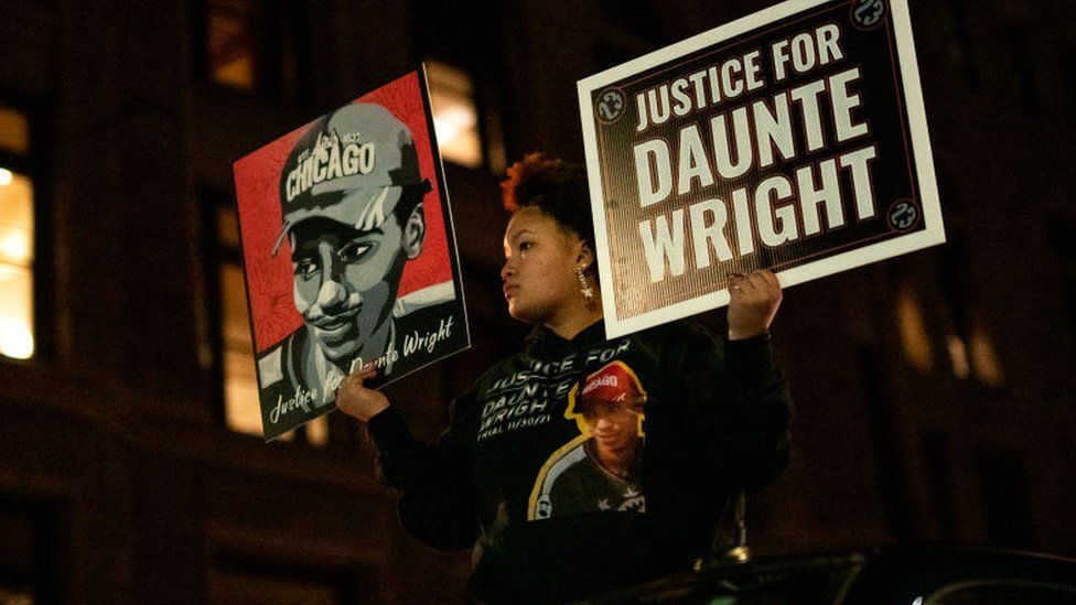 Diamond Wright, the sister of Daunte Wright, holds signs during a demonstration march on 30 November 2021 in Minneapolis, Minnesota