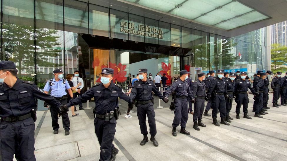 Охранники выстроились в цепочку возле штаб-квартиры Evergrande в Шэньчжэне во время акции протеста, когда покупатели требовали погашения кредитов и финансовых продуктов, 9.13.21