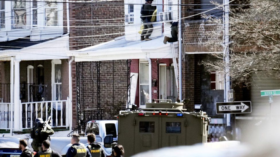 Police surround a home in Trenton, N.J., Saturday, March 16, 2024