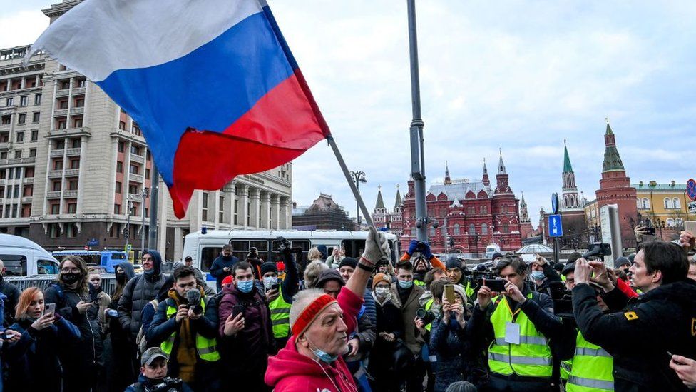 An opposition supporter waves a Russian national flag during a rally