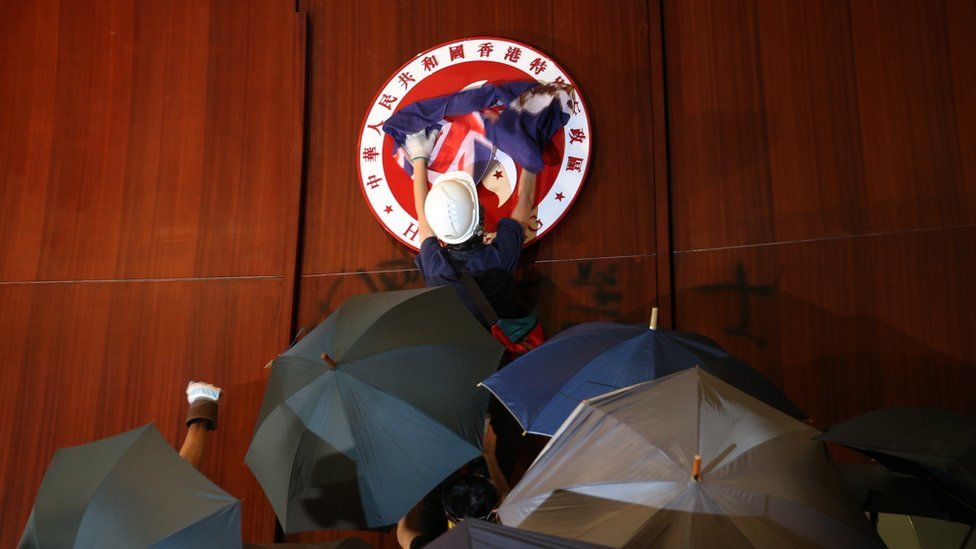 A protester wave the British colonial flag over the Bauhinia Flower emblem of Hong Kong after breaking into the main chamber of the Legislative Council building during the annual 01 July pro-democracy march in Hong Kong, China, 01 July 2019