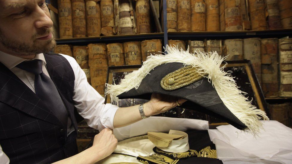 A box containing a Privy Council dress including a cocked hat with an Ostrich feather trim from 1905, displayed in a box in the archive room at Henry Poole & Co on Savile Row