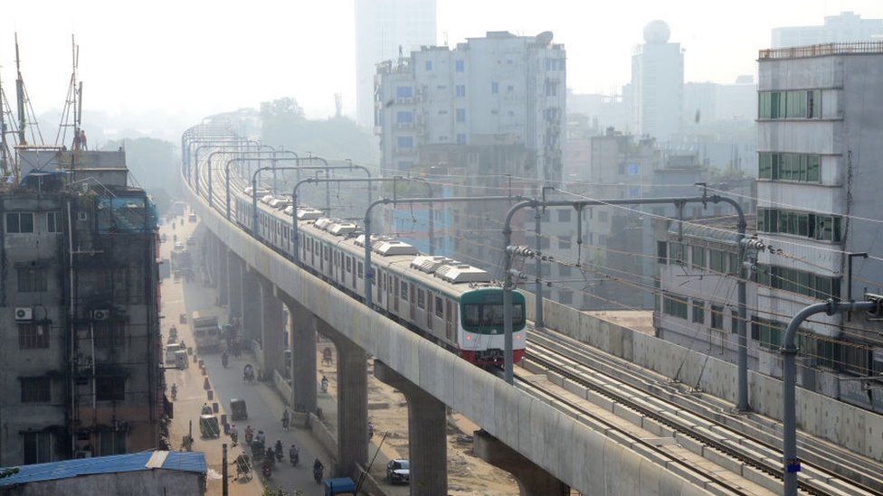 A train runs on an overpass through Dhaka with poor visibility