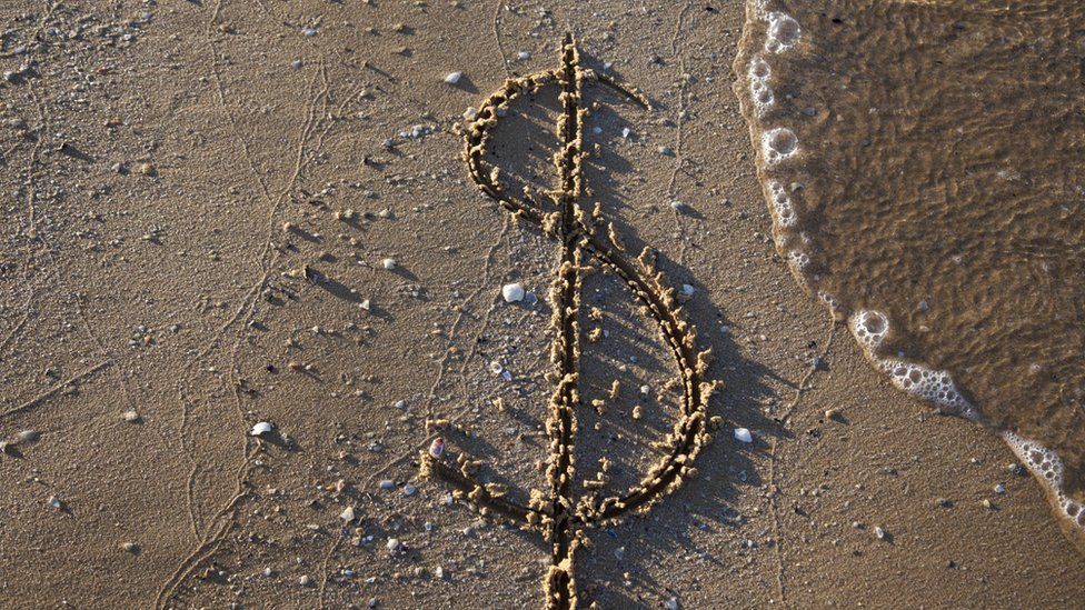 dollar symbol on beach