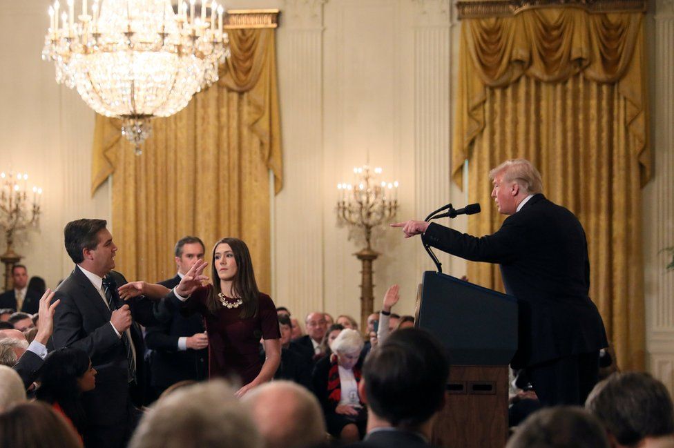 A White House staff member reaches for the microphone held by CNN's Jim Acosta as he questions US President Donald Trump during a news conference following Tuesday's mid-term US congressional elections at the White House, 7 November 2018.