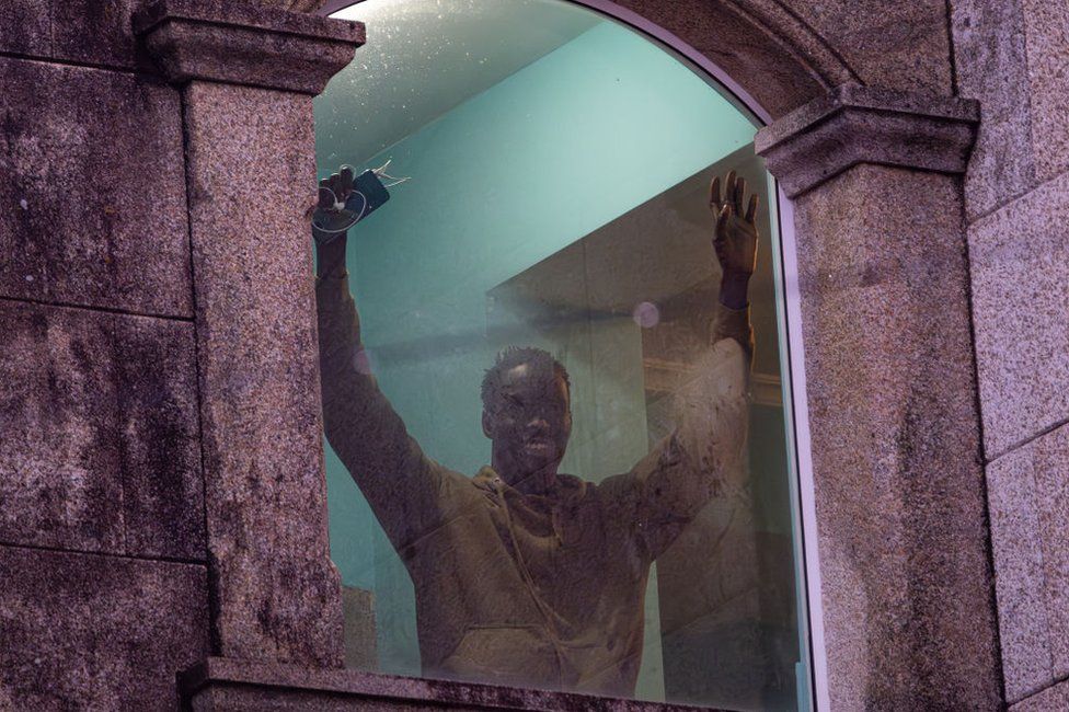 A migrant from the Canary Islands waves at one of the windows of the Baixamar hotel in Sanxenxo, Pontevedra, Galicia, Spain.