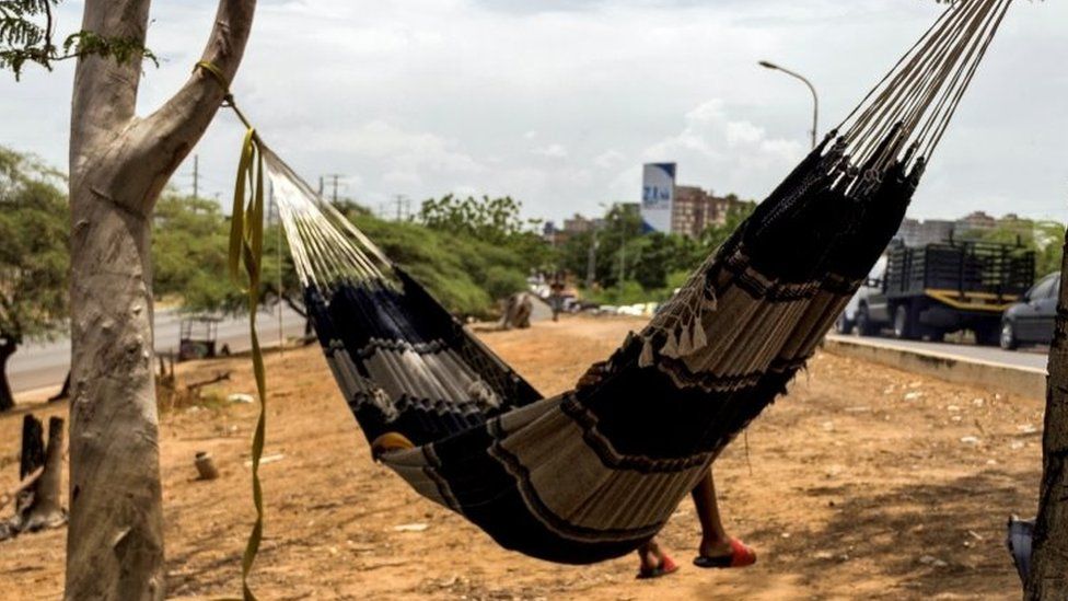 A man sleeps in a hammock as he waits next to his vehicle to load gasoline at a closed station, in Maracaibo, Venezuela, 19 September 2020 (issued 28 September 2020).