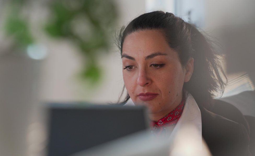 Angela sitting at the laptop