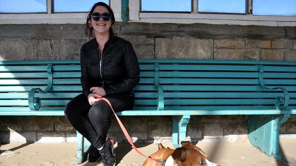 Abbie Driscoll with her dog on a bench on the seafront