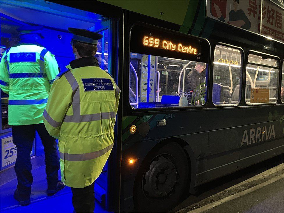 Merseyside Police officers getting on a double decker bus
