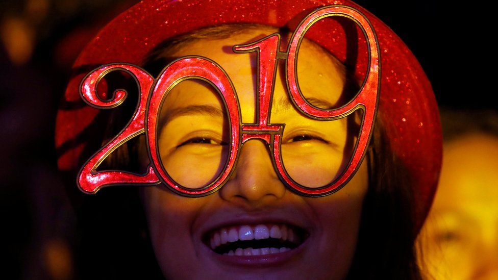 A reveller wears glasses that spell out 2019 during the New Year's Eve party in Quezon City, Metro Manila, Philippines, 31 December 2018