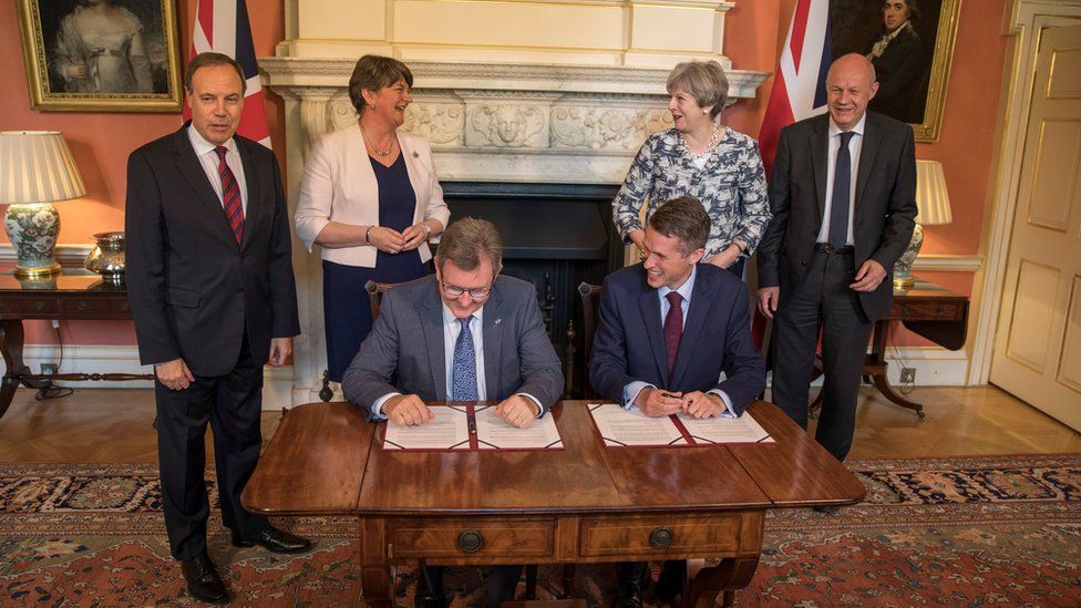 Theresa May and Conservative Party colleagues with Arlene Foster and DUP colleagues at the signing of the deal between the parties