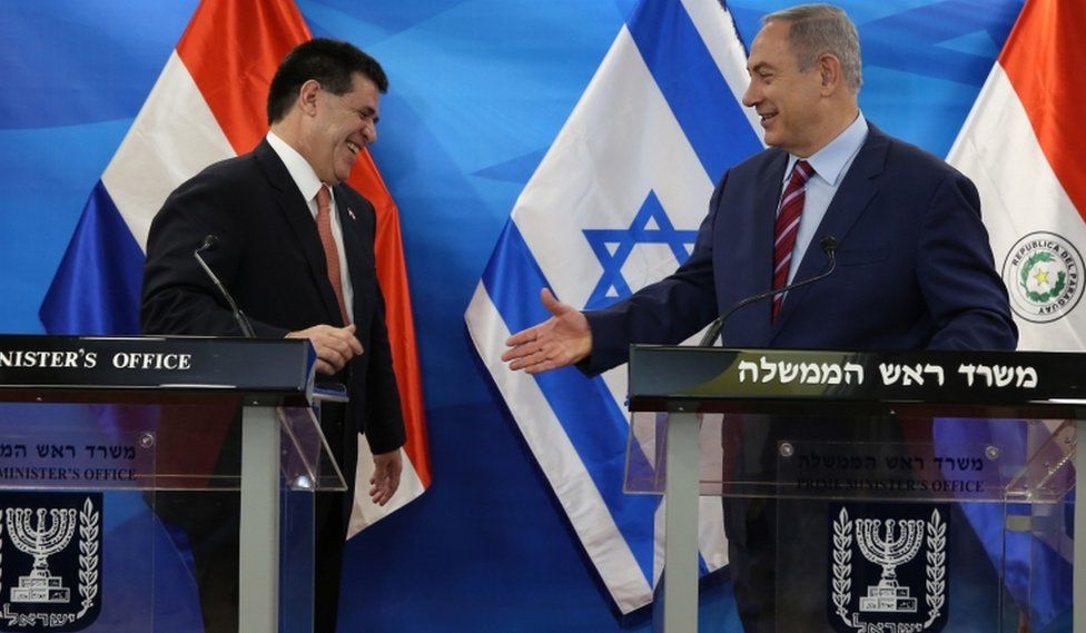 Israel's Prime Minister Benjamin Netanyahu reaches out to shake hands with Paraguayan President Horacio Cartes
