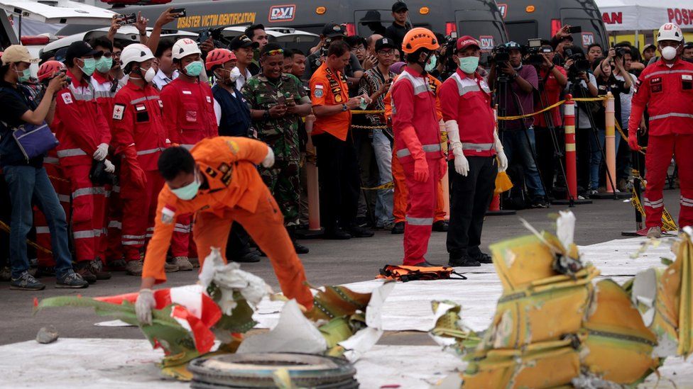 Workers look at parts of the wreckage of crashed Lion Air flight JT610