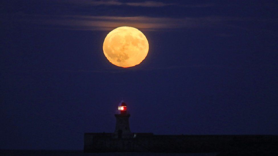 The supermoon rising above a lighthouse in South Shields, South Tyneside.