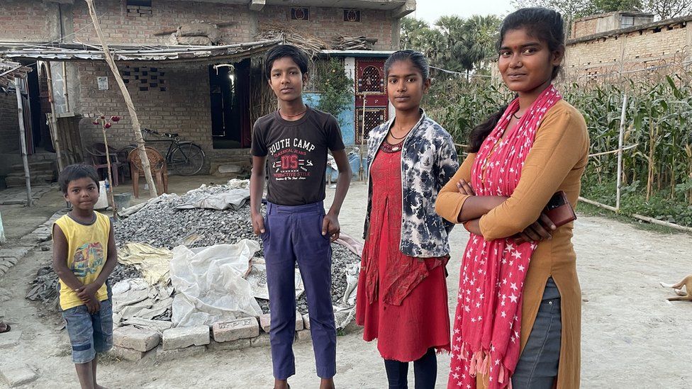 Usha's children outside their home