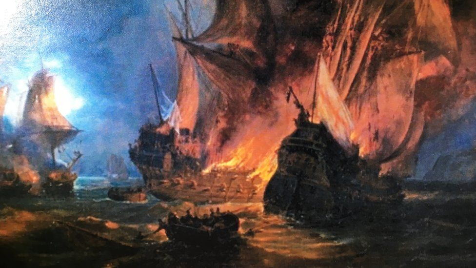 A painting shows several ships burning on the sea - the closest of which, bearing an English flag, is sinking