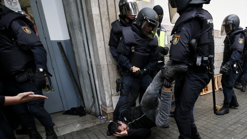 Spanish police drag a man away from a polling station in Catalonia