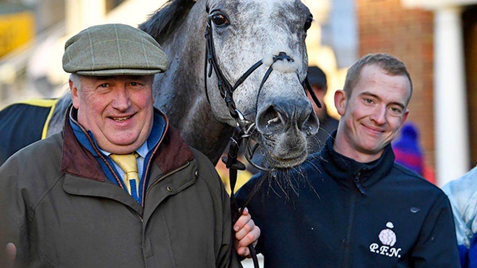 Kirkby (centre) pictured with trainer Paul Nicholls (left) and jockey Harry Cobden (right)